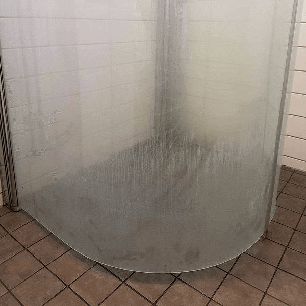 Före och efter av en dushdörr rengjord med kalkborttagning. Löser effektivt upp kalkfläckar och avlagringar, samtidigt som den avlägsnar smuts och vattenspår för en skinande yta.